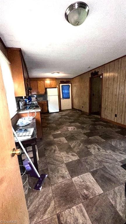 225 Dan Bryant Rd, Pilot Mountain, NC 27041 - kitchen with freestanding refrigerator, brown cabinets, wood walls, and baseboards