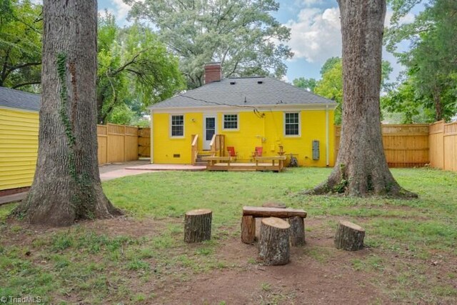 3006 Collier Dr, Greensboro, NC 27403 - rear view of house featuring a chimney, a fenced backyard, and a wooden deck