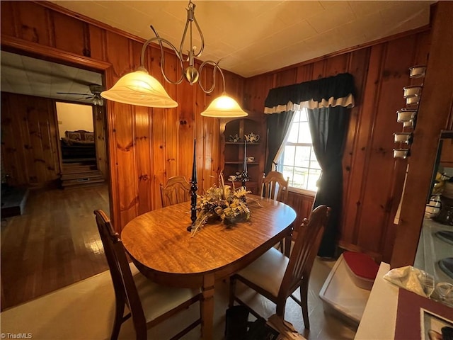 dining room featuring wooden walls and wood-type flooring