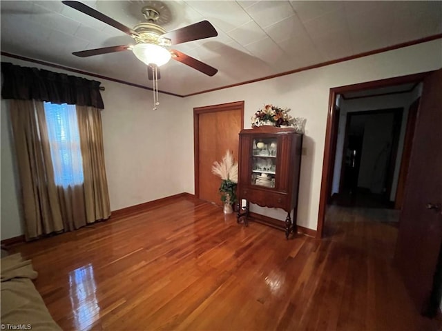 spare room featuring wood-type flooring, ceiling fan, and crown molding