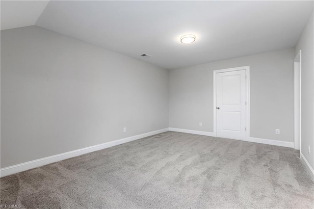 carpeted spare room featuring lofted ceiling