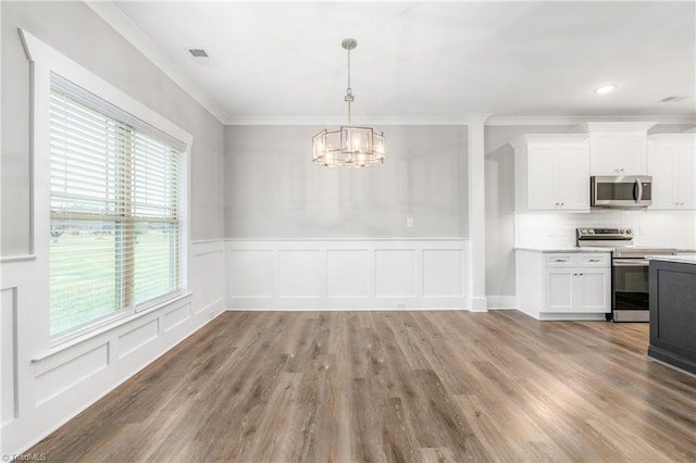 unfurnished dining area with an inviting chandelier, a wealth of natural light, and light hardwood / wood-style flooring