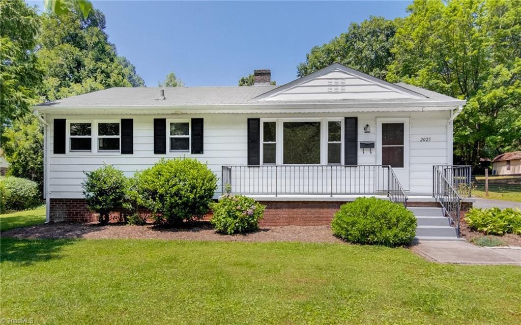 2025 Spradlin St, Winston-Salem, NC 27106 - view of front of home featuring a front yard, a chimney, and covered porch