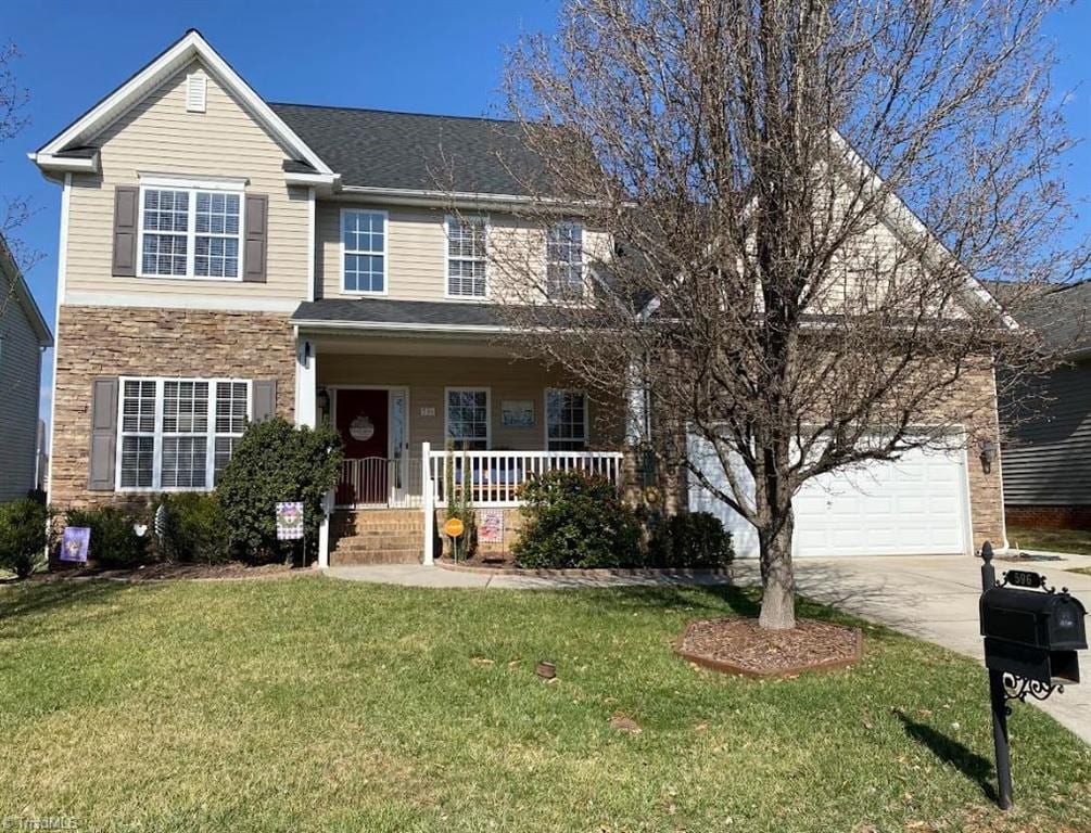 view of front facade featuring a shingled roof, a porch, a front yard, stone siding, and driveway