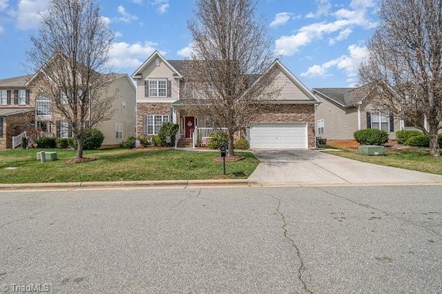 traditional-style house featuring driveway, an attached garage, and a front yard