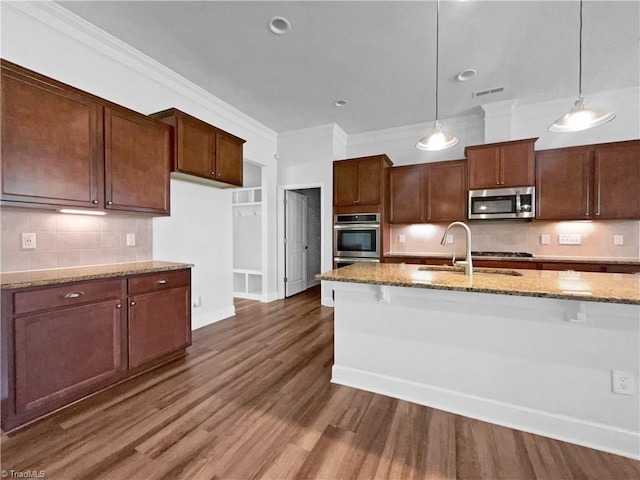 kitchen featuring light stone counters, a sink, crown molding, backsplash, and stainless steel appliances