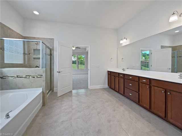 bathroom with double vanity, a stall shower, a sink, a bath, and baseboards