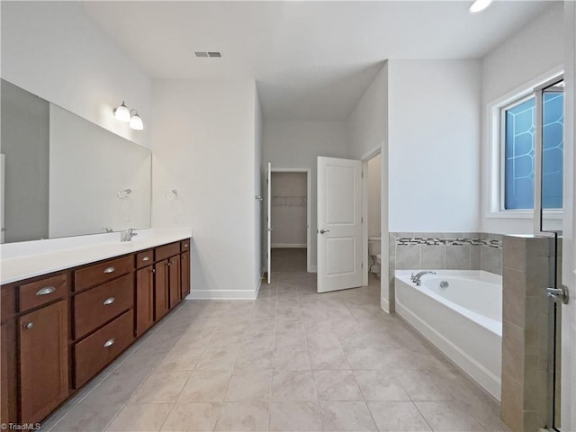 bathroom with vanity, visible vents, tile patterned floors, a walk in closet, and a bath