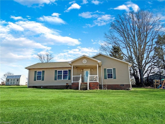 ranch-style house featuring an outbuilding, covered porch, and a front lawn