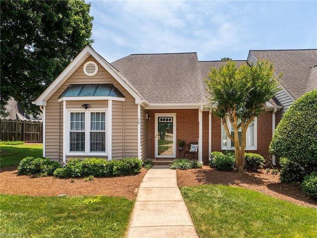 10 Cedar Knoll Ct, Greensboro, NC 27407 - view of front facade with roof with shingles, brick siding, a standing seam roof, and a metal roof