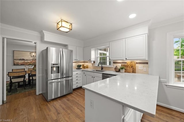 3408 Deep Green Dr, Greensboro, NC 27410 - kitchen with appliances with stainless steel finishes, a sink, a peninsula, white cabinetry, and ornamental molding