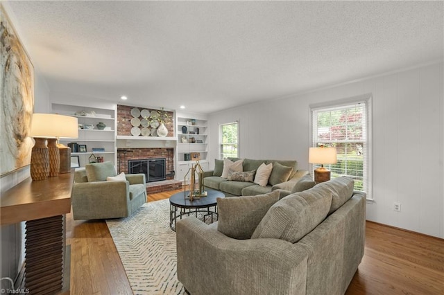 3408 Deep Green Dr, Greensboro, NC 27410 - living area with wood finished floors, a textured ceiling, a fireplace, and built in features
