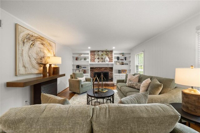 3408 Deep Green Dr, Greensboro, NC 27410 - living room featuring wood finished floors, a brick fireplace, crown molding, and built in features