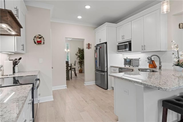 kitchen featuring white cabinets, appliances with stainless steel finishes, custom range hood, and sink