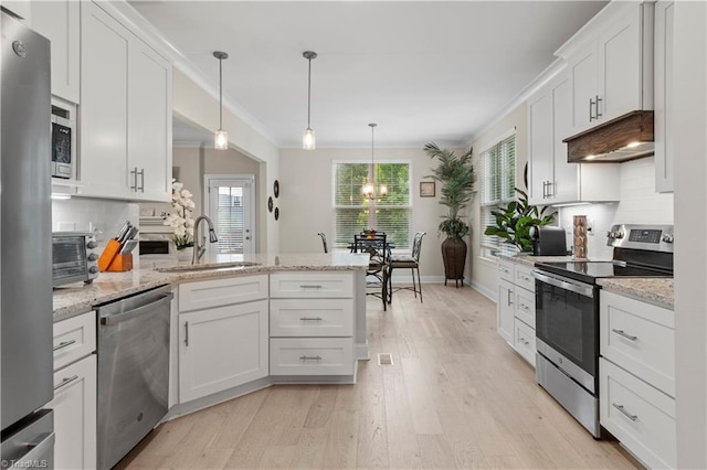 kitchen featuring white cabinets, hanging light fixtures, sink, appliances with stainless steel finishes, and tasteful backsplash