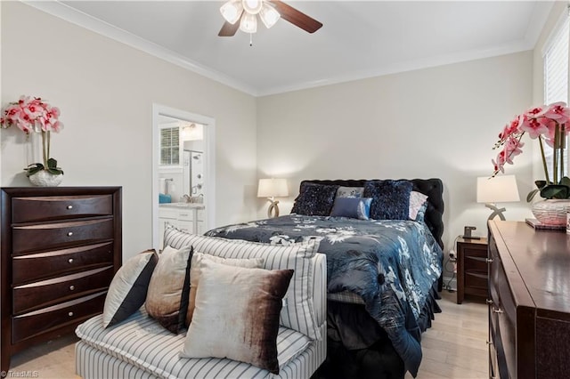 bedroom featuring ceiling fan, light wood-type flooring, crown molding, and ensuite bath