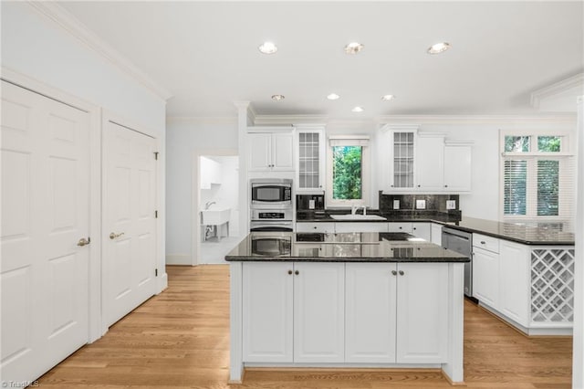 1000 Brookmeade Dr, Winston-Salem, NC 27106 - kitchen featuring appliances with stainless steel finishes, ornamental molding, a peninsula, white cabinets, and glass insert cabinets