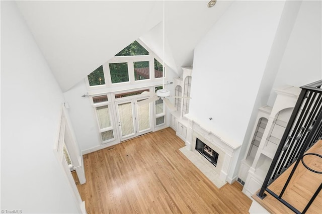 1000 Brookmeade Dr, Winston-Salem, NC 27106 - unfurnished living room featuring high vaulted ceiling, a fireplace with flush hearth, and light wood-style flooring