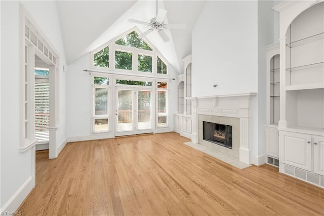 1000 Brookmeade Dr, Winston-Salem, NC 27106 - unfurnished living room with a ceiling fan, a tiled fireplace, light wood-style flooring, and high vaulted ceiling