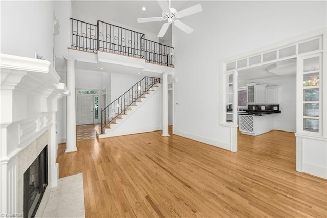 1000 Brookmeade Dr, Winston-Salem, NC 27106 - unfurnished living room with plenty of natural light, light wood-style floors, a ceiling fan, stairway, and a towering ceiling