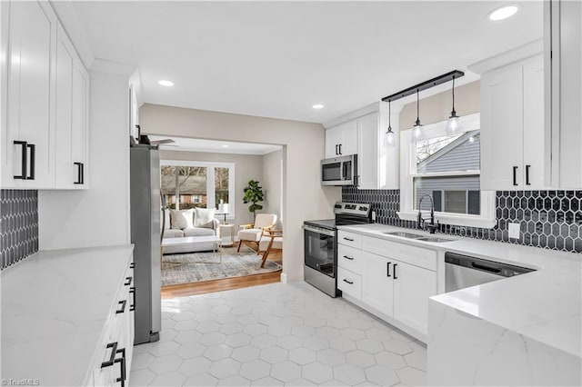 kitchen featuring a sink, appliances with stainless steel finishes, and white cabinetry