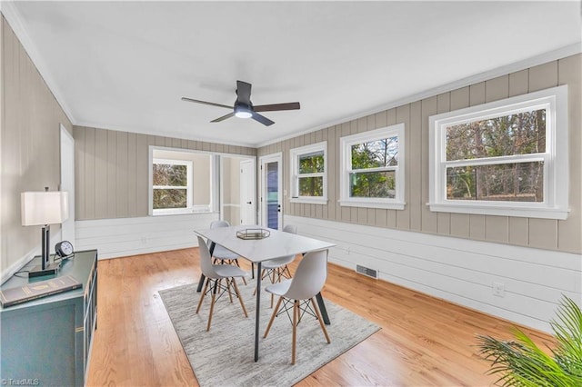 dining room featuring a wealth of natural light, visible vents, light wood-style floors, and ornamental molding