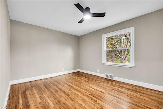 spare room featuring visible vents, ceiling fan, baseboards, and hardwood / wood-style flooring