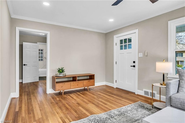 entryway featuring visible vents, ornamental molding, baseboards, and wood finished floors