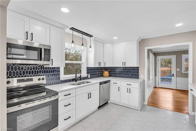 kitchen with a healthy amount of sunlight, stainless steel appliances, light countertops, and a sink