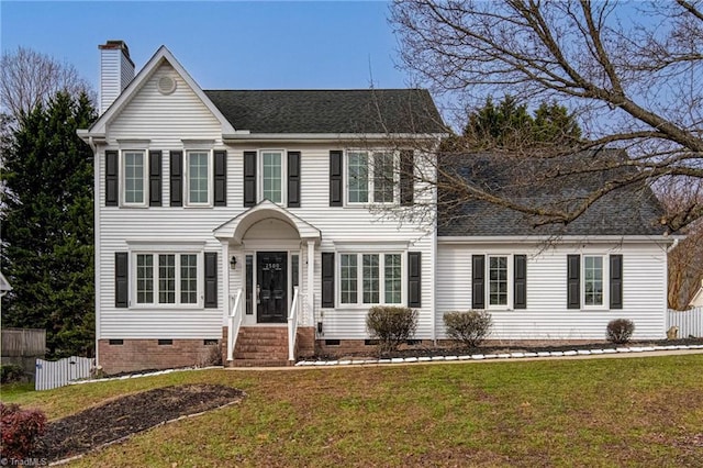 colonial-style house featuring a front lawn