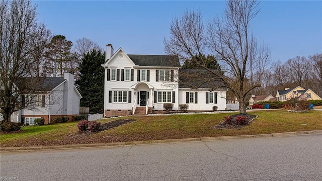 colonial home featuring a front lawn