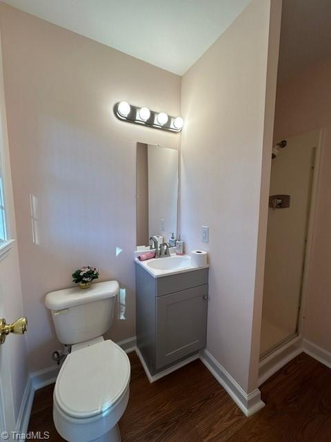 bathroom with wood-type flooring, vanity, and a shower