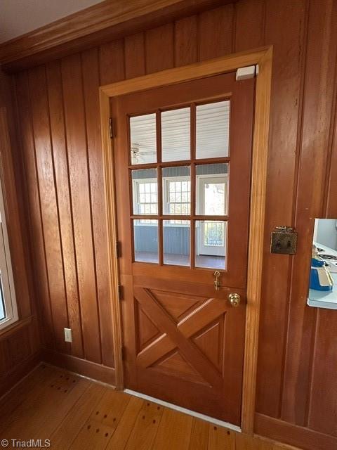 entryway with hardwood / wood-style floors and wood walls