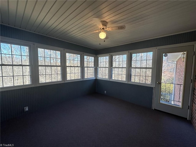 unfurnished sunroom featuring ceiling fan and a wealth of natural light