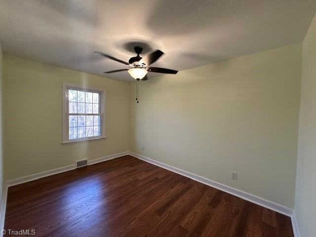 unfurnished room featuring dark hardwood / wood-style floors and ceiling fan