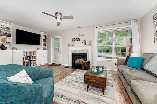 1896 Winds Dr, Winston-Salem, NC 27127 - living room featuring wood finished floors, ceiling fan, and a fireplace with raised hearth