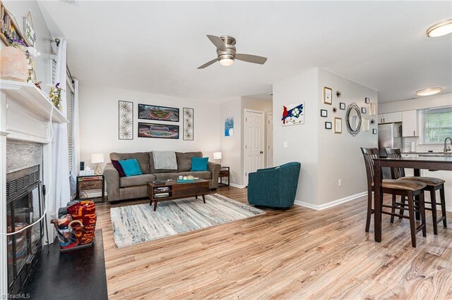 1896 Winds Dr, Winston-Salem, NC 27127 - living area featuring light wood-style floors, a ceiling fan, and a glass covered fireplace
