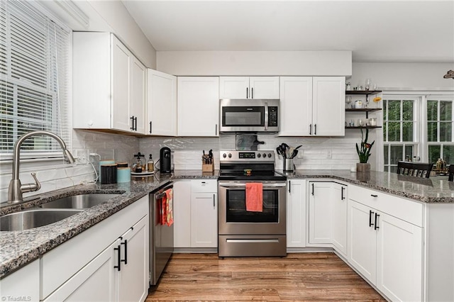 1896 Winds Dr, Winston-Salem, NC 27127 - kitchen featuring appliances with stainless steel finishes, open shelves, white cabinets, backsplash, and a peninsula
