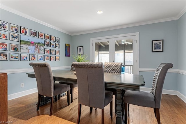 dining space with baseboards, ornamental molding, wood finished floors, and french doors