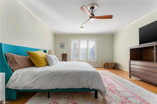 bedroom featuring baseboards, ornamental molding, and wood finished floors