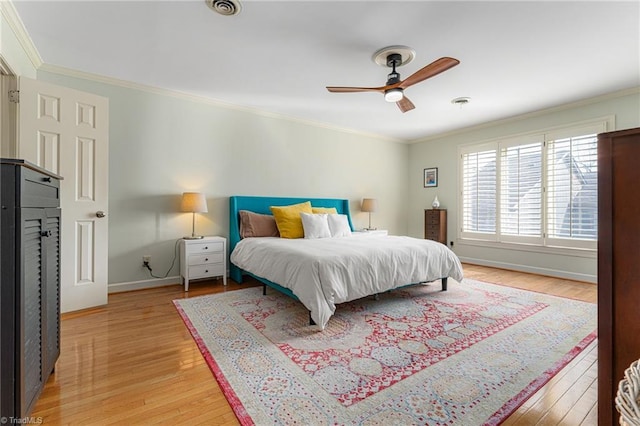 bedroom with visible vents, baseboards, light wood-style flooring, and crown molding