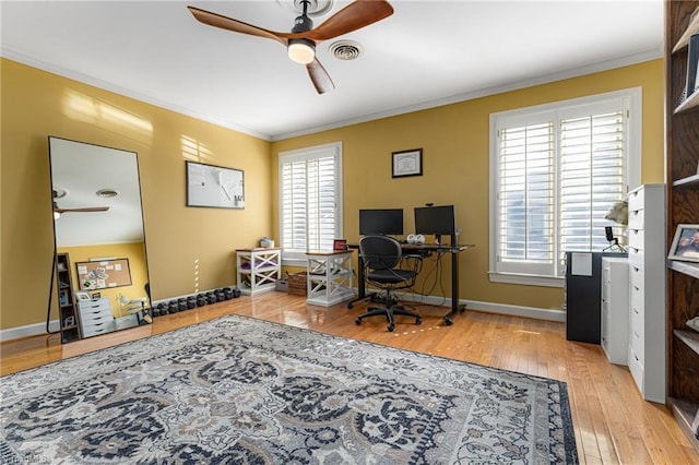 office space with visible vents, hardwood / wood-style floors, ornamental molding, and a wealth of natural light