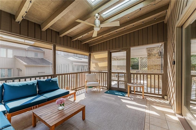 sunroom featuring ceiling fan and lofted ceiling with skylight