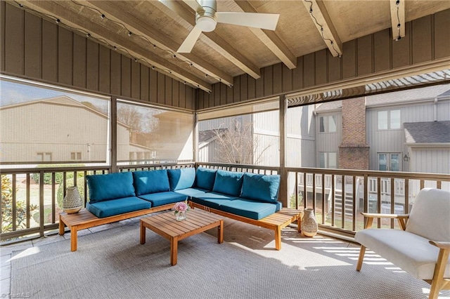 sunroom / solarium with a ceiling fan and vaulted ceiling with beams