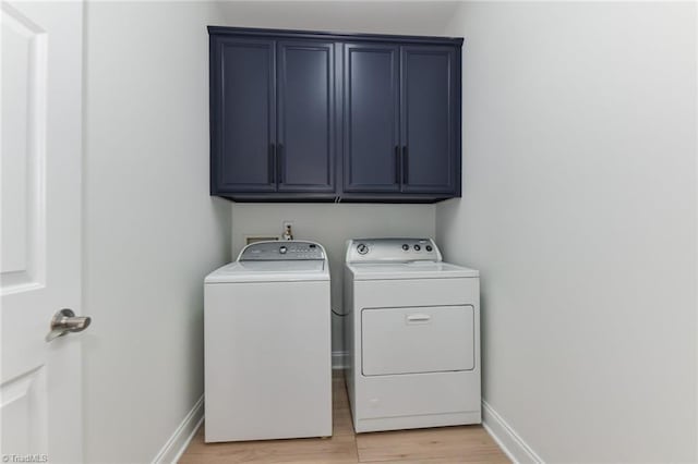 4294 Plantation Ridge Ln, Greensboro, NC 27409 - laundry room featuring cabinet space, washer and dryer, and light wood-style flooring