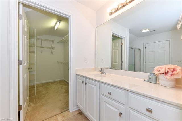4294 Plantation Ridge Ln, Greensboro, NC 27409 - full bathroom featuring vanity, vaulted ceiling, a walk in closet, and a shower with door