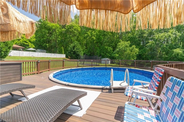 view of swimming pool with a fenced in pool, fence, and a deck