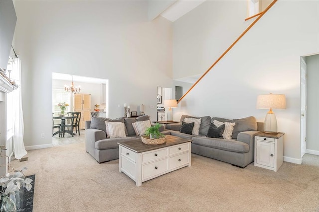 living area with baseboards, a high ceiling, a chandelier, and light colored carpet