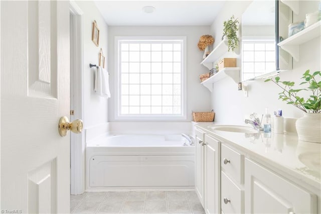 bathroom with double vanity, a sink, and a garden tub