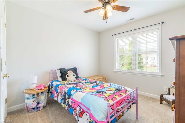 carpeted bedroom featuring baseboards, a ceiling fan, and visible vents
